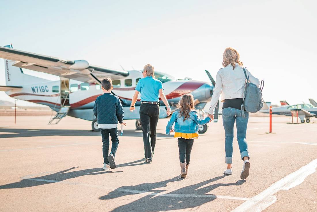 Family walking across an airfield towards their plane